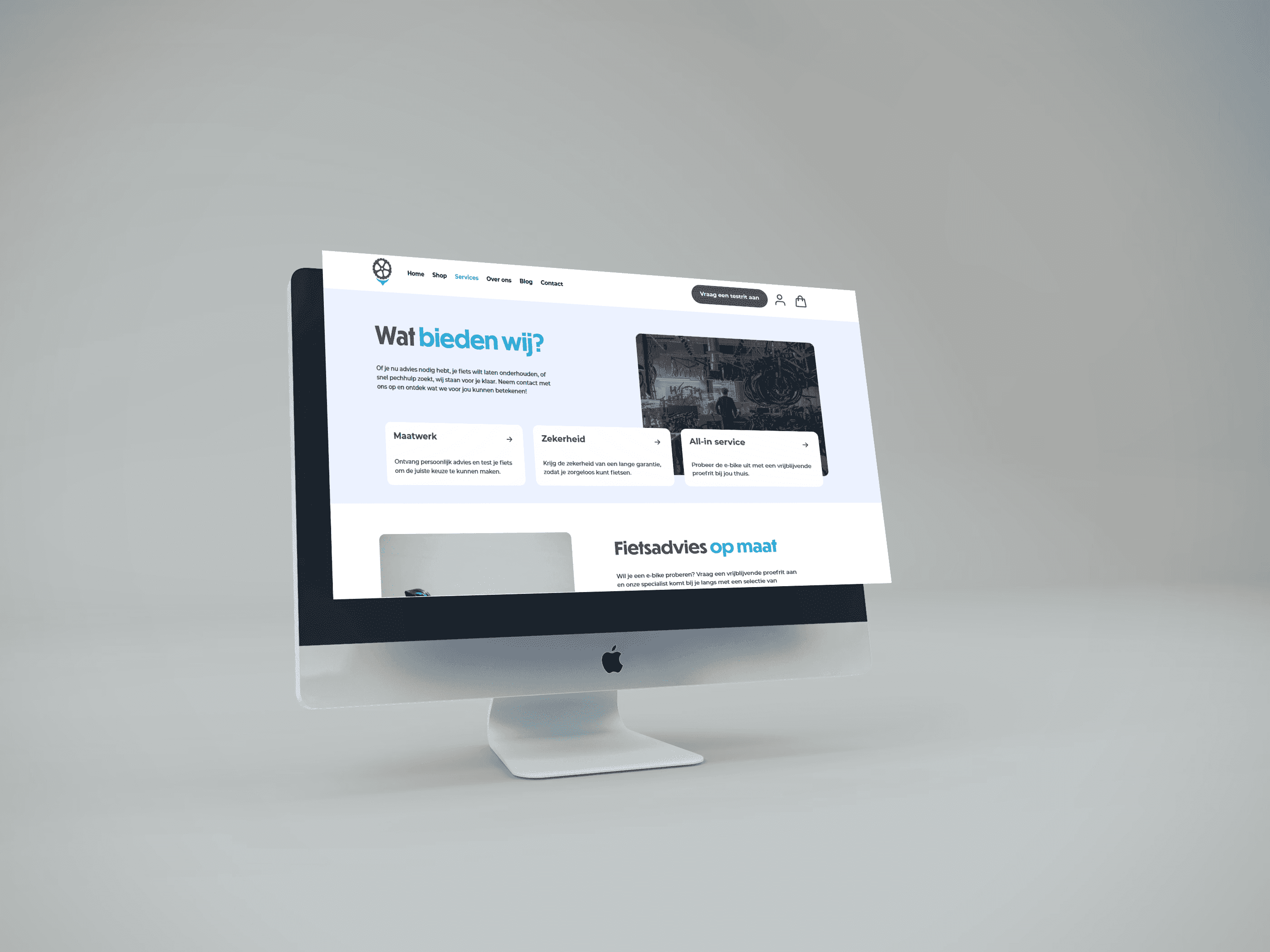 Modern silver iMac computer displaying a clean website with "Wat bieden wij?" text.
