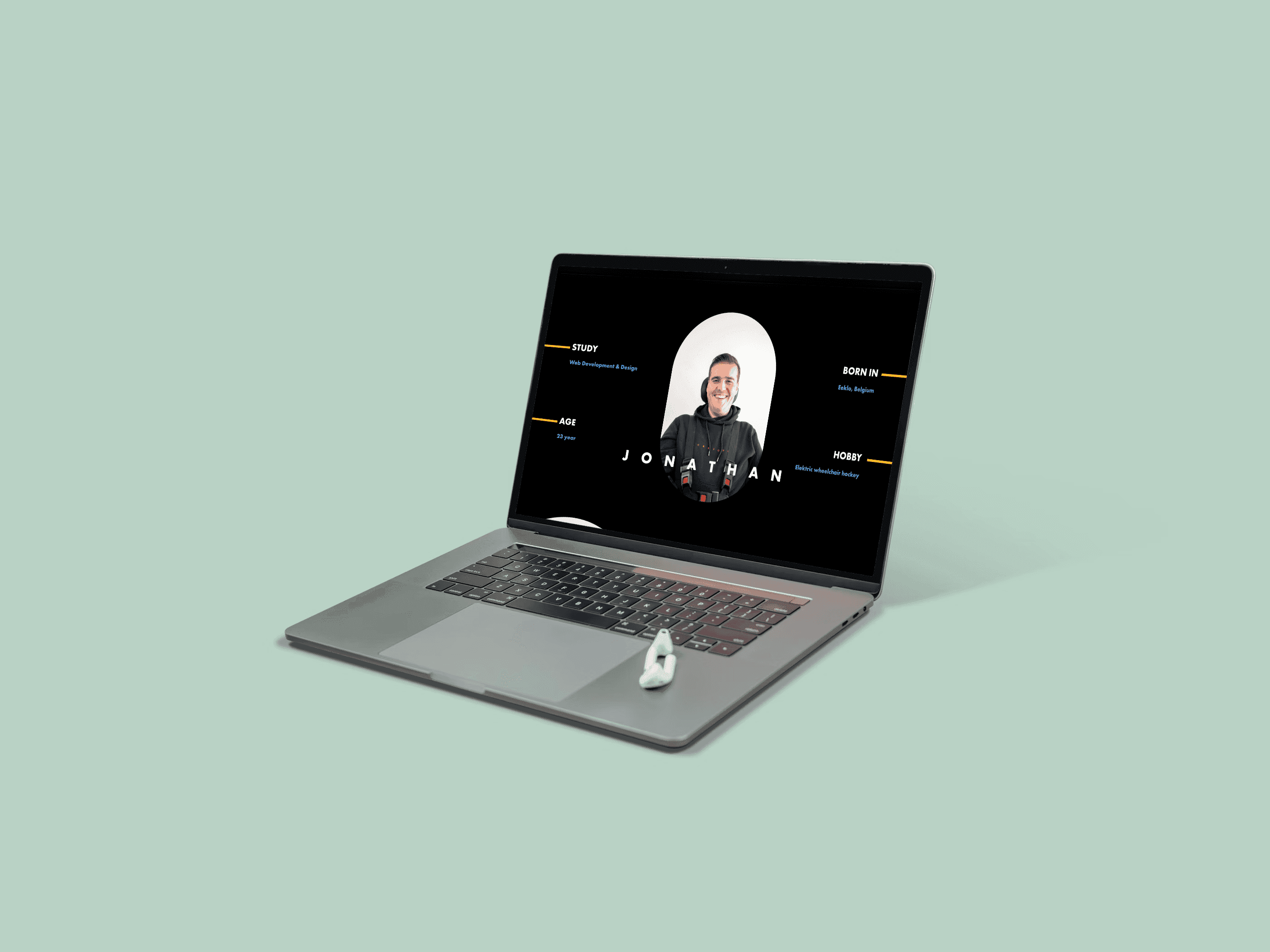 Silver laptop displays a profile page with a man's photo and information, a USB drive attached.